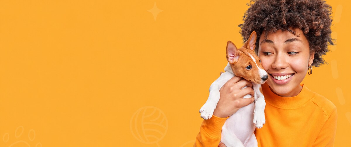 Woman holding a small dog on an orange background
